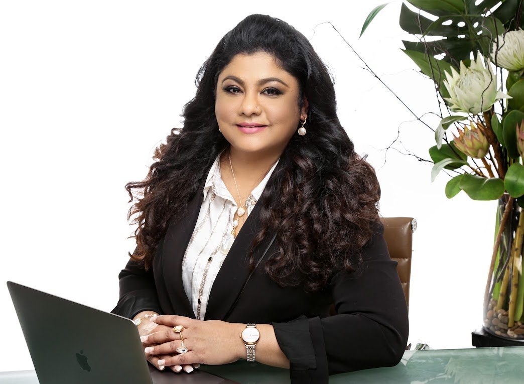 Uma Panch seated at a desk with her laptop